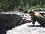 Christiaan zit bij een waterval in de Rock Mountains